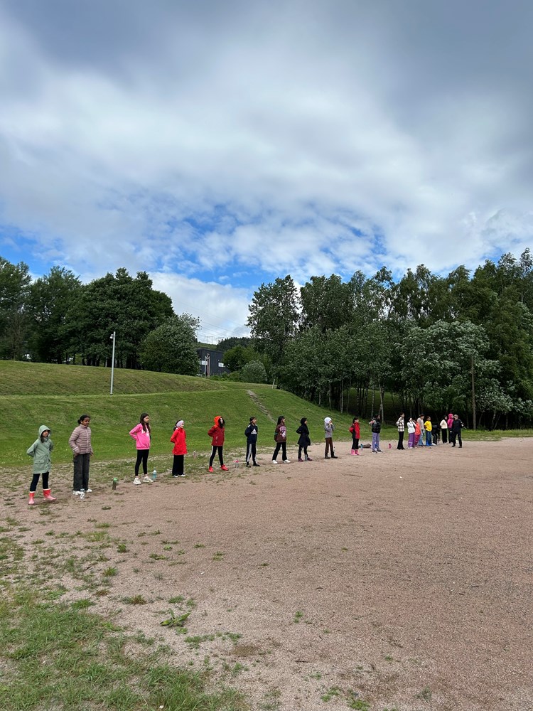 en gruppe mennesker som går på en grusvei