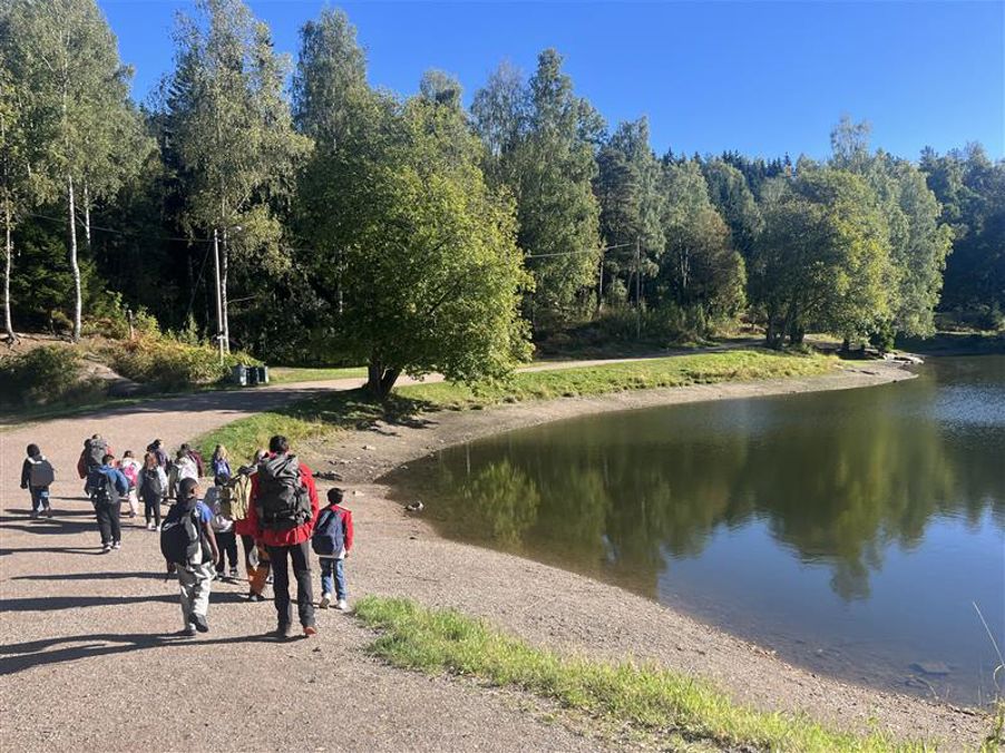 en gruppe mennesker som går langs en elv