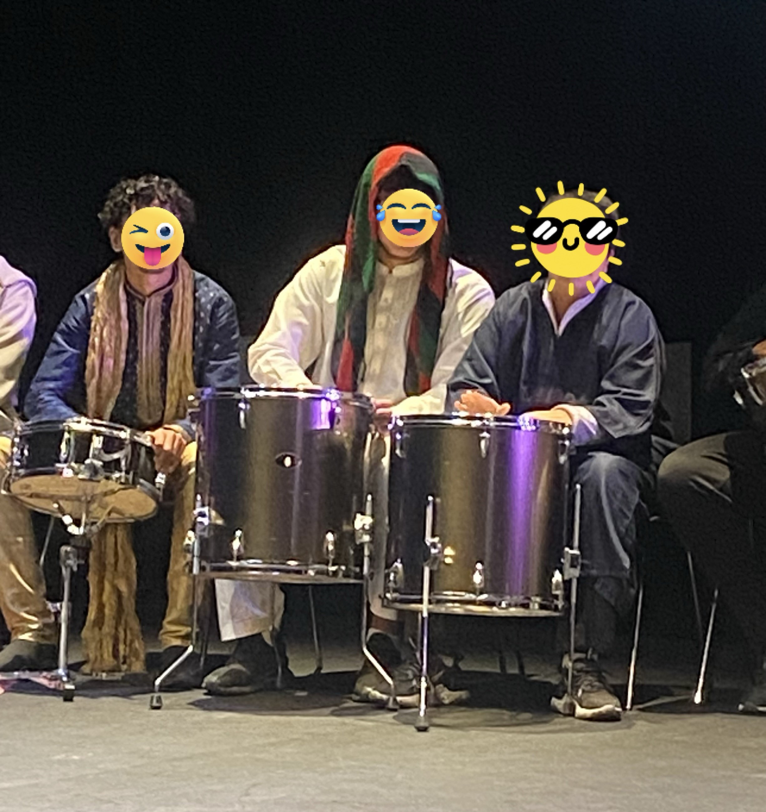 en gruppe mennesker som har på seg klær og spiller trommer