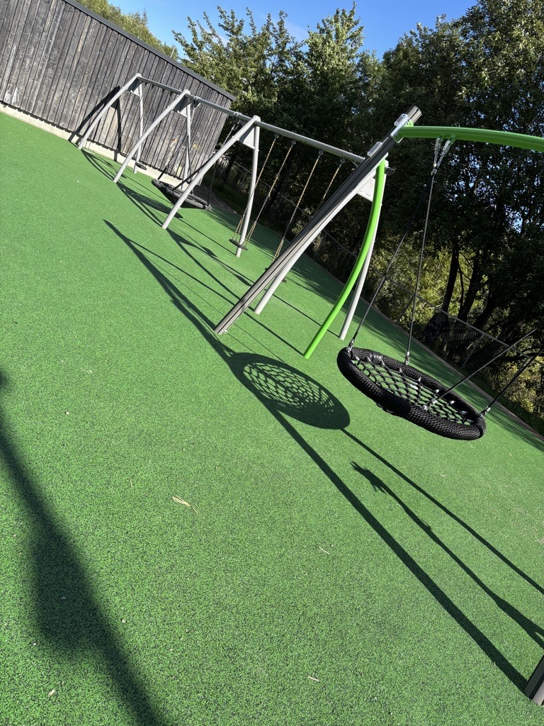 en grønn sklie i en hage