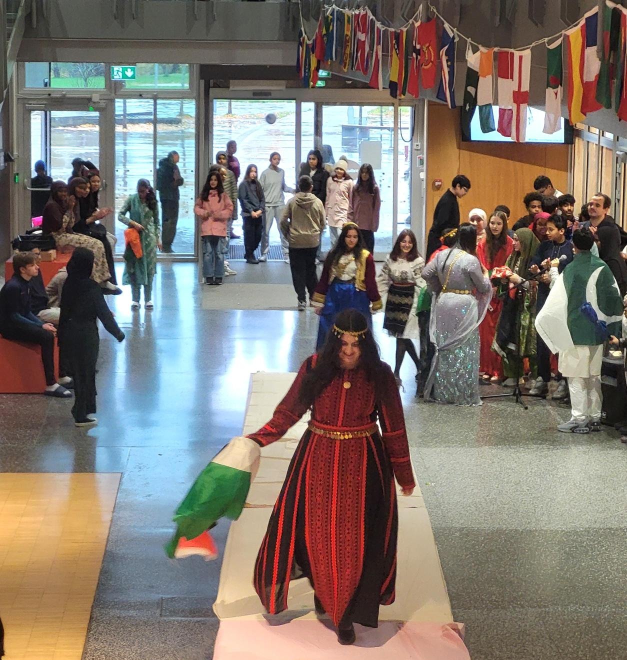 en person i rød kjole som danser i et rom fullt av mennesker