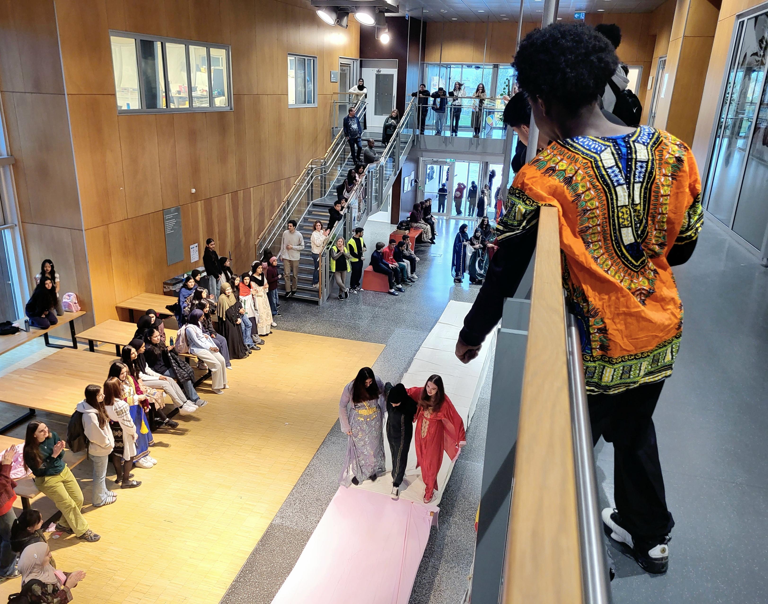 en person i et plagg som går nedover en gang med en mengde mennesker