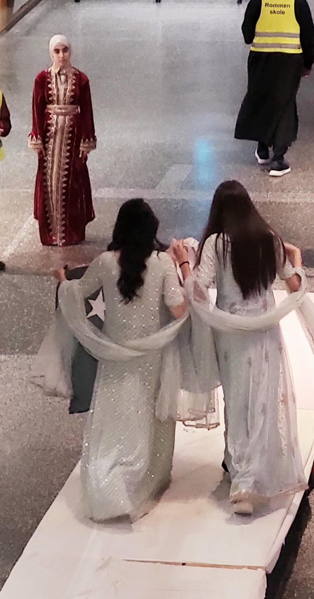 en person som sitter på en benk ved siden av en statue av en person