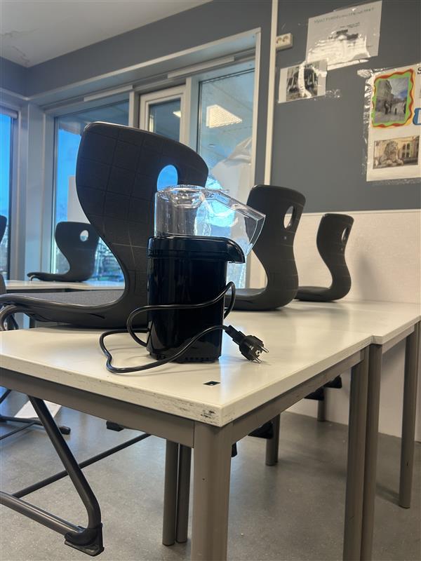 et skrivebord med et glass og en bøtte på