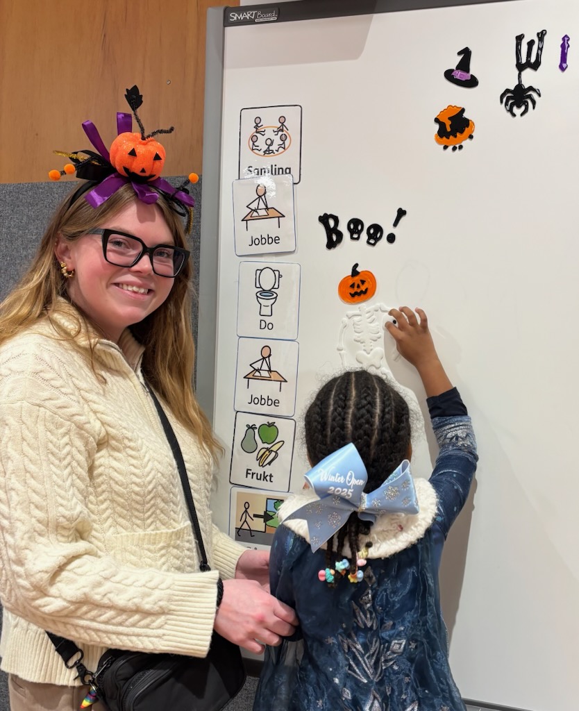 en person med hatt og briller som holder en tegning av en katt