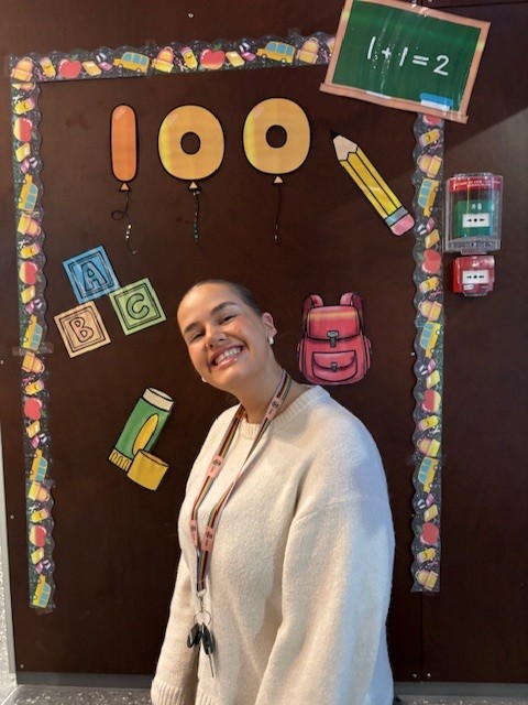 en person som smiler med et skilt bak seg