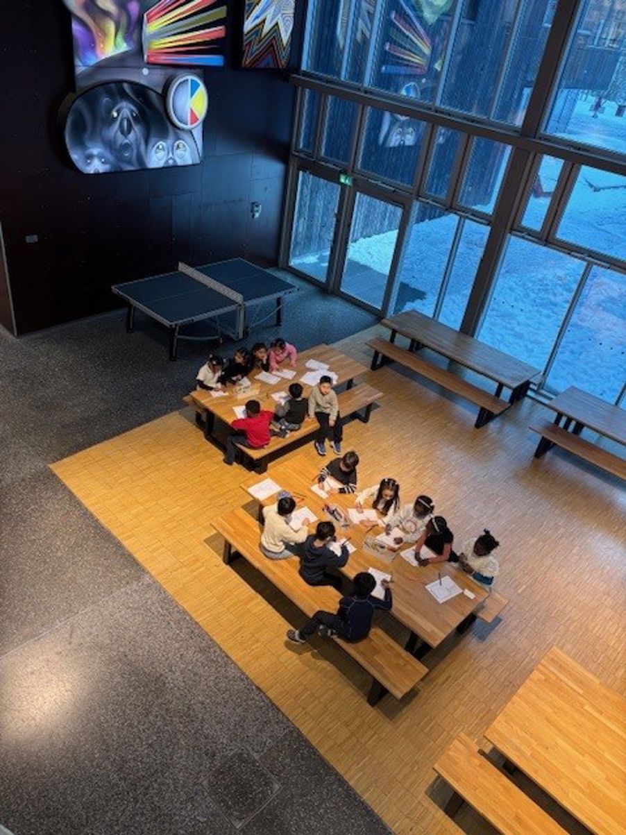 en gruppe mennesker som sitter ved pulter i et rom en gruppe mennesker som sitter ved pulter i et rom