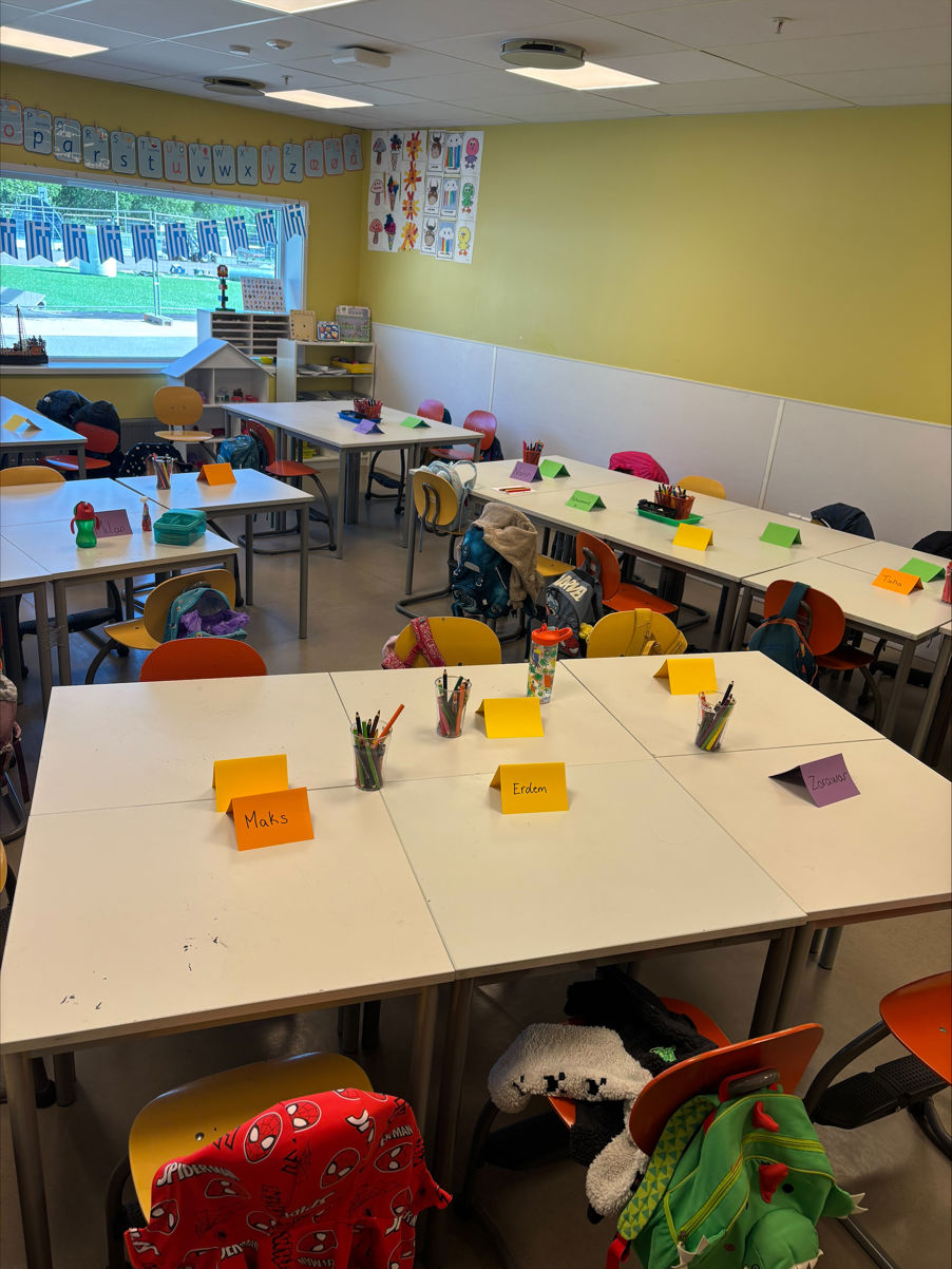 et klasserom med bord og stoler