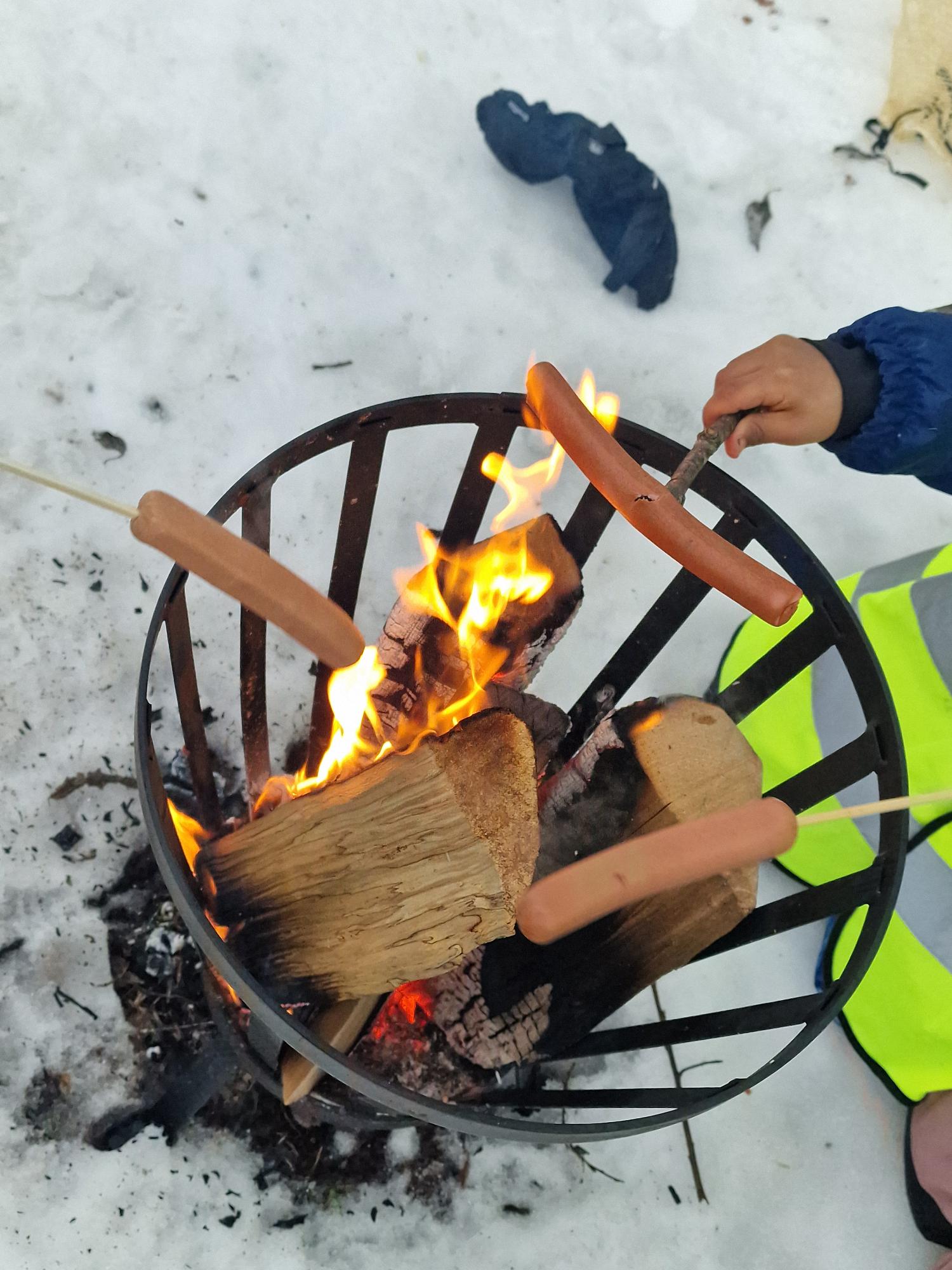 en person som holder en pinne over et bål