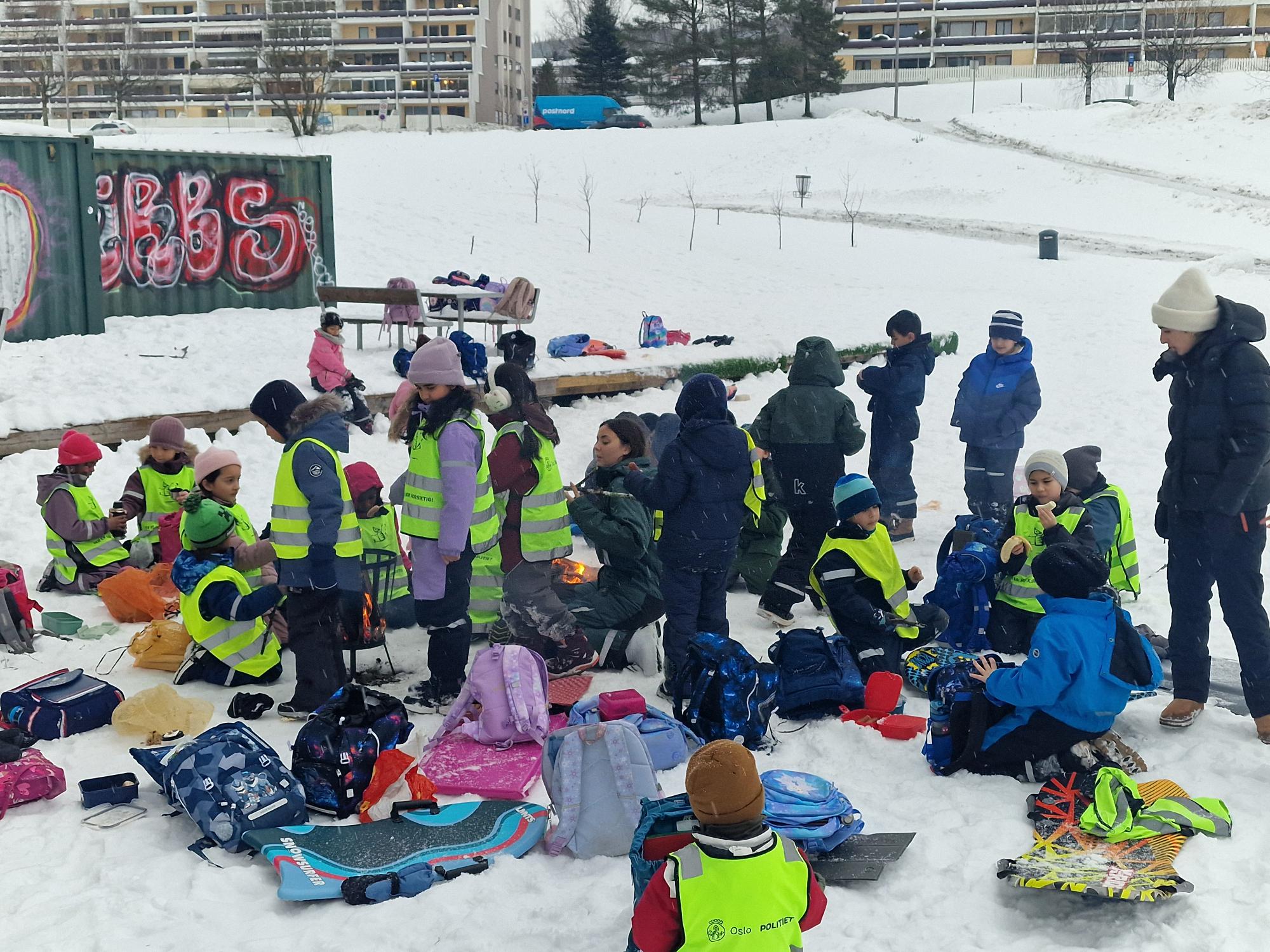 en gruppe mennesker som sitter på snøen
