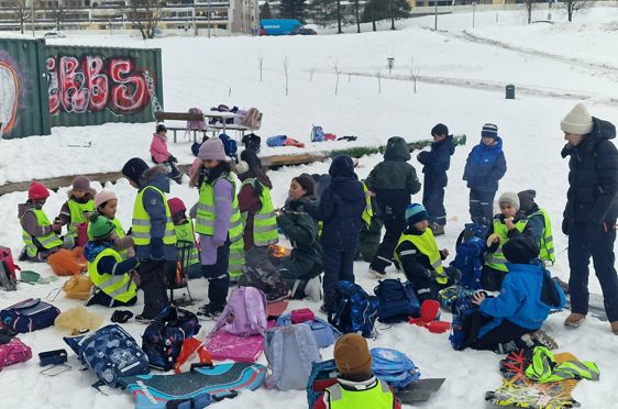 en gruppe mennesker som sitter på snøen
